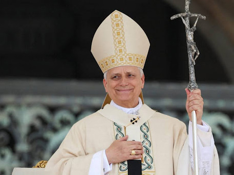The pope in ceremonial vestments holding a silver crucifix staff