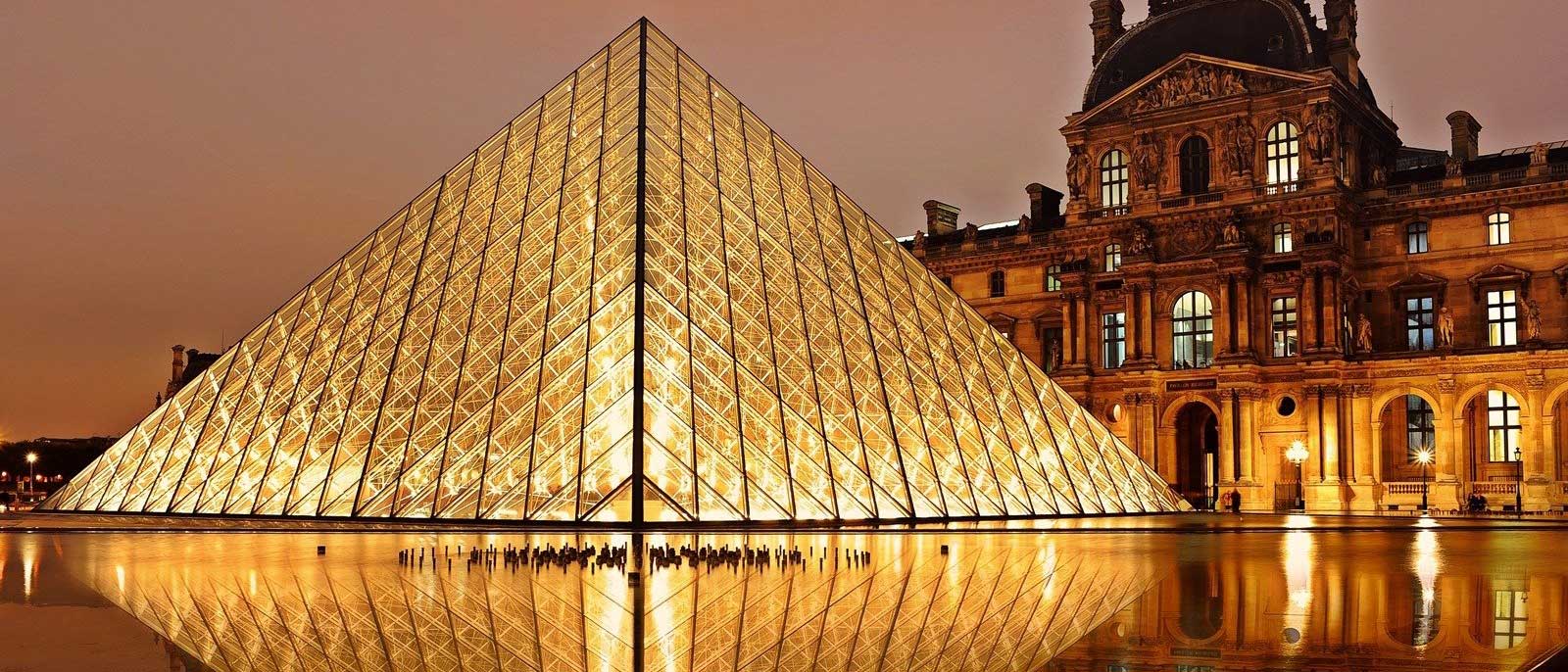 the louvre pyramid at night all lit up