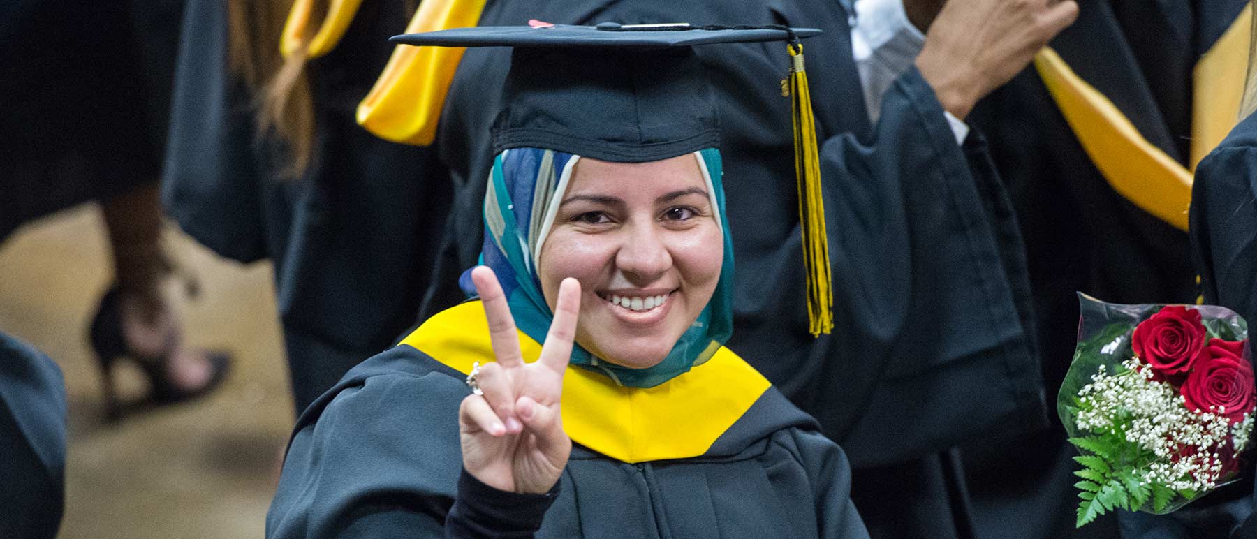 a v. c. u. graduate holding up a peace sign during the commencement ceremony