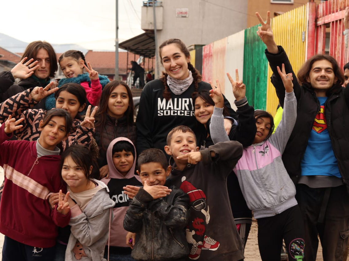Marina Pugh stands in the middle of a group of children