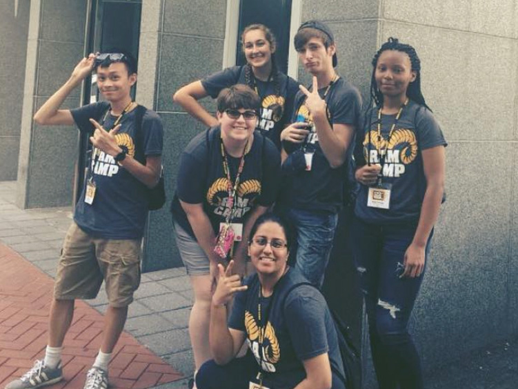 A group of VCU students in Ram Camp t-shirts pose outside of a building